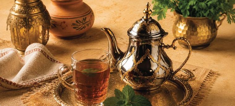 Jemenitische thee in een glas met een theepot